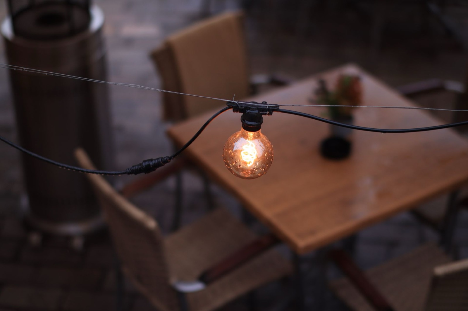Warm string lights over a cozy gathering table, the kind of welcoming feel we want on our team